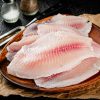Fresh fish fillet on a wooden plate. On a black background. High quality photo