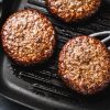 Closeup of meat beef patties grilled on pan. Cooking process
