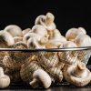 Fresh mushrooms in a colander. On a black background. High quality photo