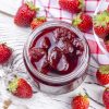 Homemade delicious strawberry jam and strawberry on a rustic wooden table