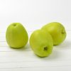Three green apples on white wooden  background