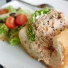 Tuna sandwich and fresh salad on a plate on table